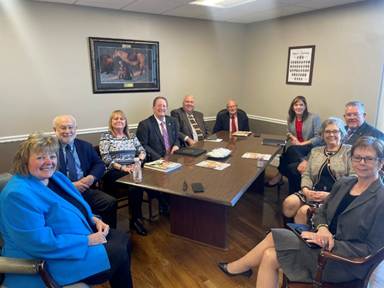 A group of people sitting around a tableAI-generated content may be incorrect.