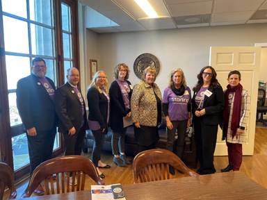 A group of people standing in a roomAI-generated content may be incorrect.