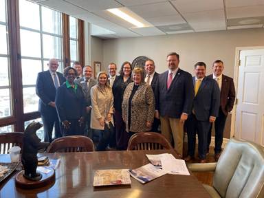 A group of people standing in a roomAI-generated content may be incorrect.