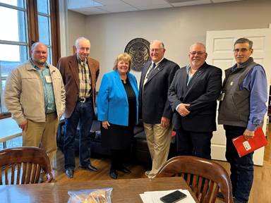 A group of people standing in a roomAI-generated content may be incorrect.