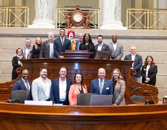 A group of people sitting on a bench in front of a clockAI-generated content may be incorrect.